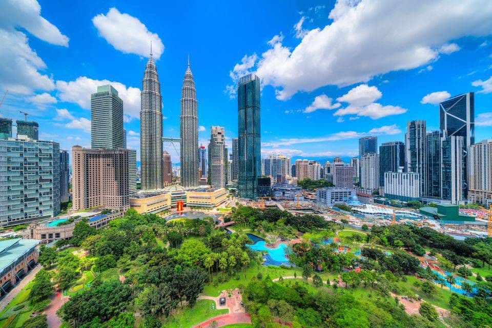Kuala Lumpur skyline with the Petronas Twin Towers and office towers rising above the gardens of KLCC Park