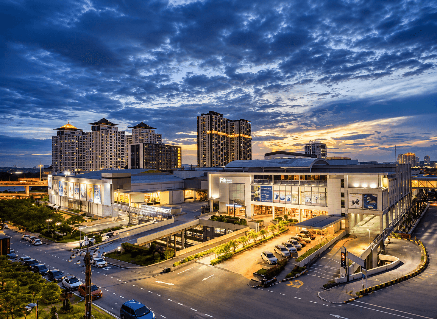 A shopping mall and high-rise apartment blocks lit at dusk in the Sungai Besi area of Kuala Lumpur